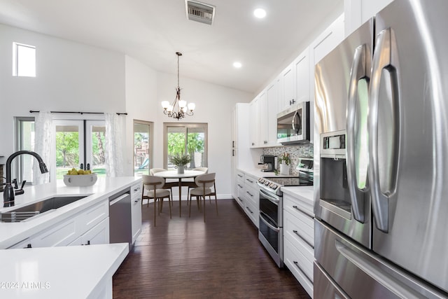 kitchen featuring hanging light fixtures, sink, white cabinetry, stainless steel appliances, and dark hardwood / wood-style floors