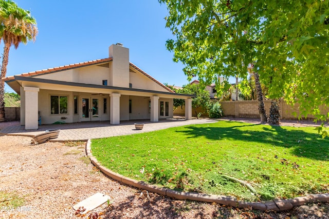 back of property featuring a patio and a yard