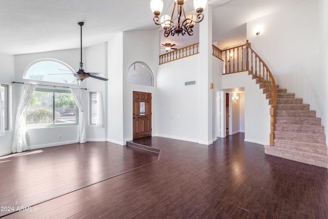 entryway with ceiling fan with notable chandelier, a towering ceiling, and dark hardwood / wood-style flooring