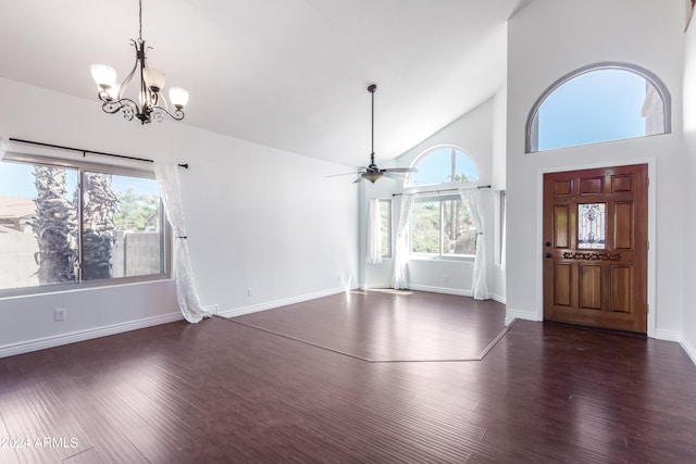 entrance foyer featuring a healthy amount of sunlight, ceiling fan with notable chandelier, dark wood-type flooring, and high vaulted ceiling