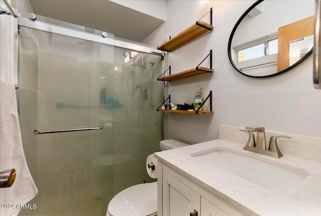 bathroom with vanity, toilet, and a shower with shower door