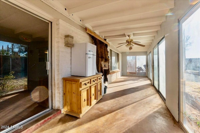 sunroom / solarium featuring beam ceiling and ceiling fan