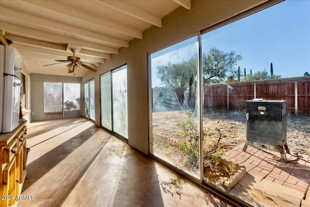 sunroom / solarium featuring beam ceiling and ceiling fan