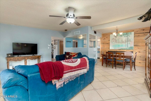 tiled bedroom with a textured ceiling, ceiling fan with notable chandelier, and wooden walls