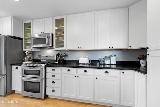 kitchen with white cabinetry, light wood-type flooring, and appliances with stainless steel finishes