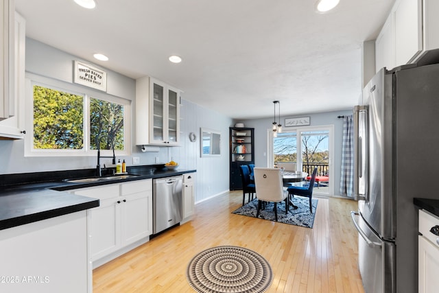 kitchen with pendant lighting, sink, white cabinetry, and appliances with stainless steel finishes