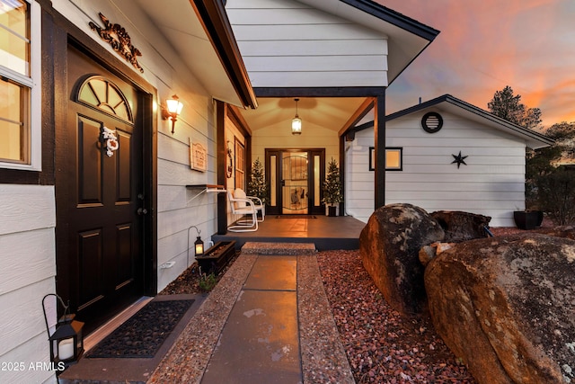 exterior entry at dusk featuring a porch