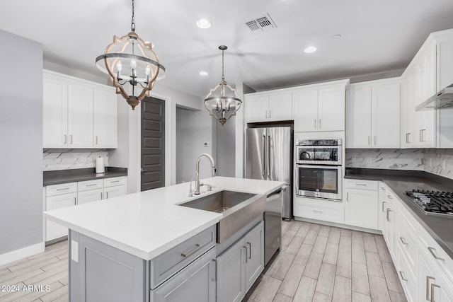 kitchen with pendant lighting, white cabinetry, and a notable chandelier