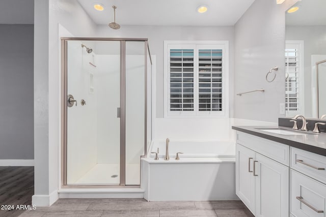 bathroom featuring shower with separate bathtub and vanity