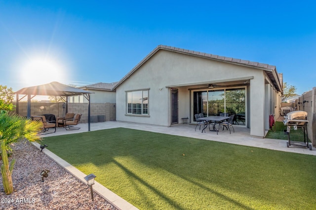 back of house with a yard, a patio, and ceiling fan