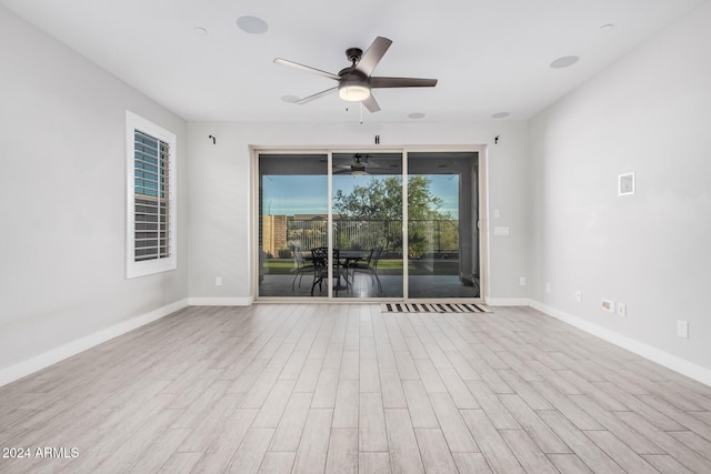 empty room with ceiling fan and light hardwood / wood-style floors