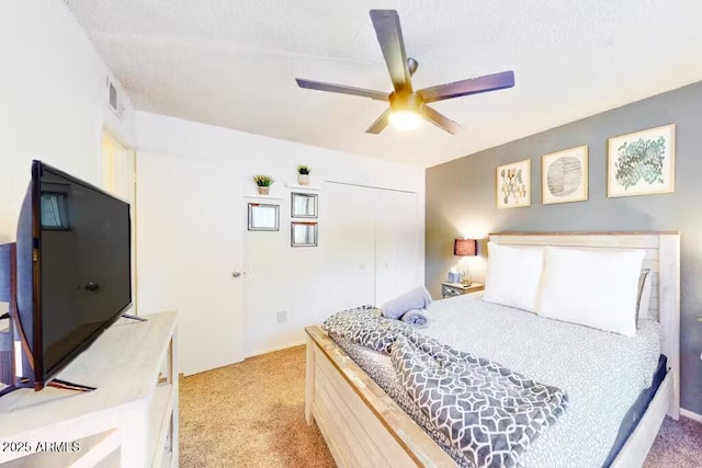 bedroom featuring light colored carpet, a ceiling fan, and a closet