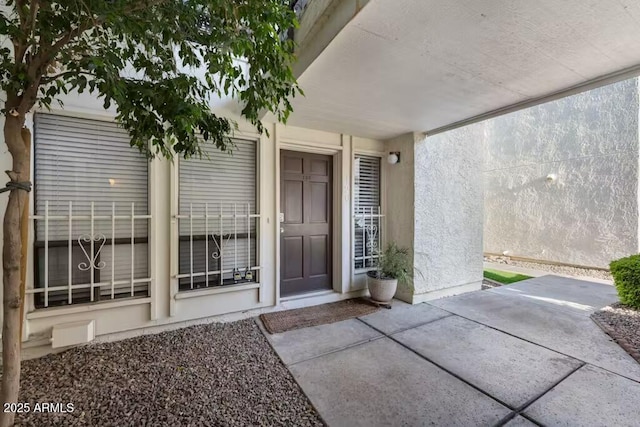 doorway to property featuring a patio area and stucco siding
