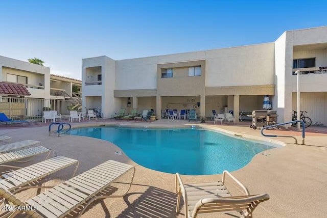 community pool featuring a patio and fence