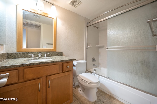 full bathroom featuring toilet, combined bath / shower with glass door, tile patterned flooring, and vanity