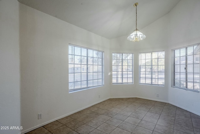 tiled spare room featuring lofted ceiling and an inviting chandelier