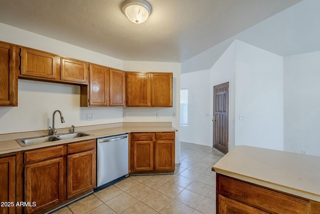 kitchen featuring stainless steel dishwasher, light tile patterned floors, sink, and a textured ceiling