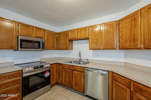 kitchen featuring light tile patterned flooring, sink, and appliances with stainless steel finishes