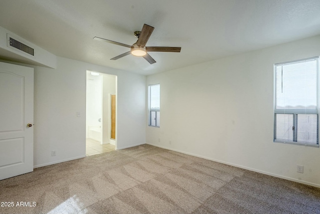 spare room with ceiling fan and light colored carpet