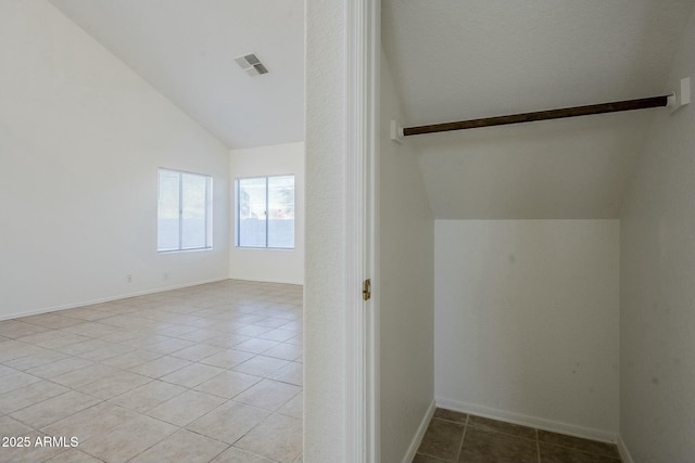 interior space with lofted ceiling and light tile patterned floors