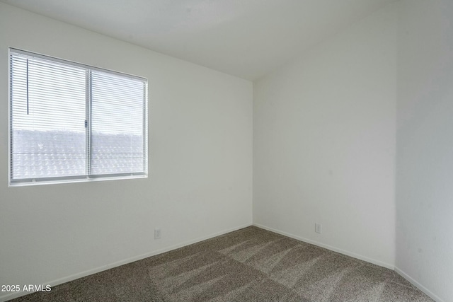 spare room with dark carpet