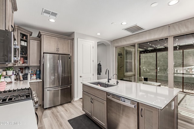 2499 S Entwistle St, Gilbert, AZ 85295 - kitchen featuring appliances with stainless steel finishes, a sink, light countertops, light wood-style flooring, and recessed lighting