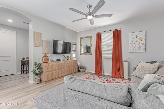 2499 S Entwistle St, Gilbert, AZ 85295 - living room featuring ceiling fan, light wood-style flooring, arched walkways, and baseboards