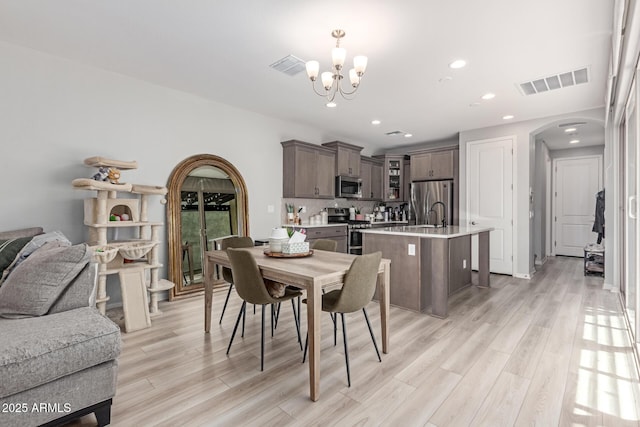 2499 S Entwistle St, Gilbert, AZ 85295 - dining space featuring arched walkways, a chandelier, light wood-type flooring, and recessed lighting