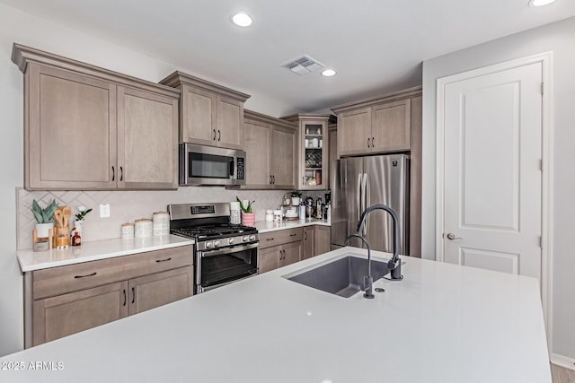 2499 S Entwistle St, Gilbert, AZ 85295 - kitchen featuring stainless steel appliances, a sink, recessed lighting, glass insert cabinets, and decorative backsplash