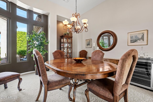 carpeted dining space with high vaulted ceiling and an inviting chandelier