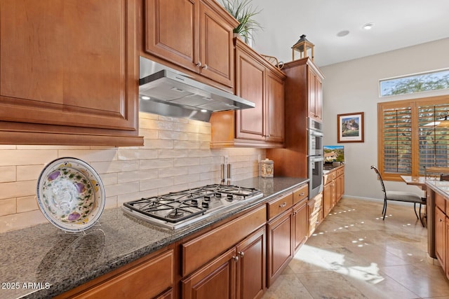 kitchen with backsplash, dark stone countertops, and stainless steel appliances