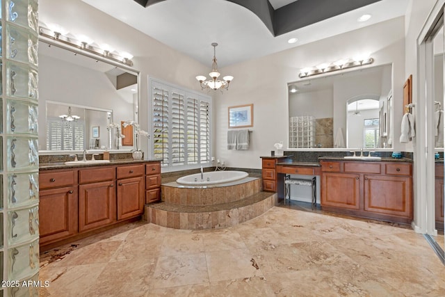 bathroom featuring plus walk in shower, vanity, and a notable chandelier