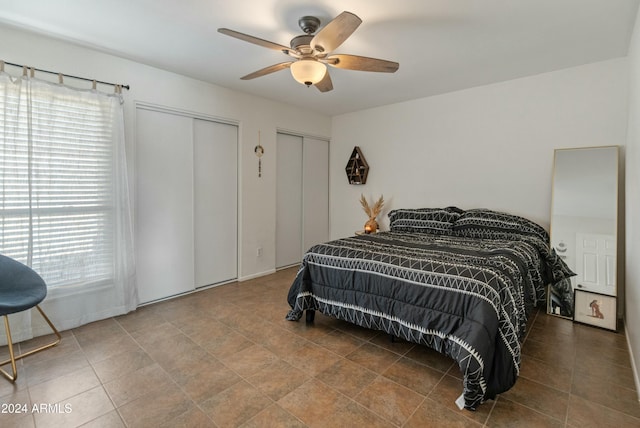 bedroom with ceiling fan and two closets