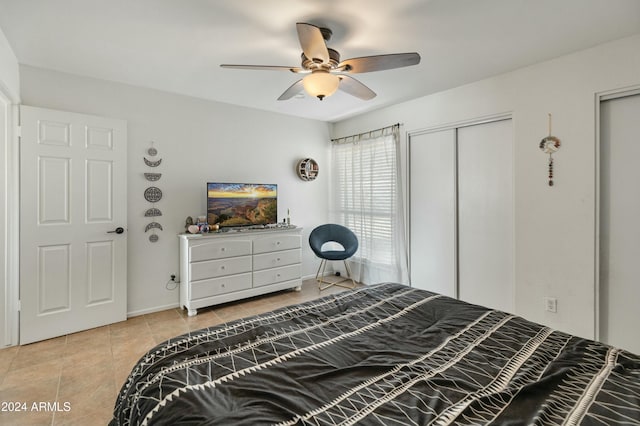 bedroom featuring ceiling fan, light tile patterned floors, and a closet