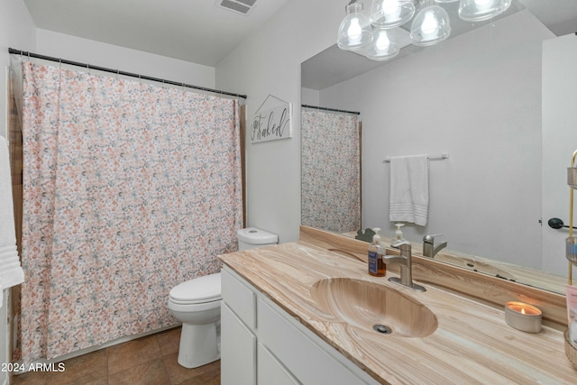 bathroom featuring tile patterned flooring, vanity, and toilet