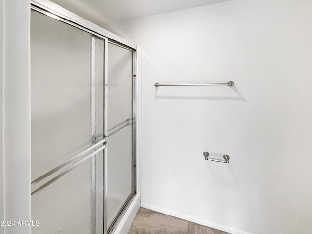 bathroom with a shower with door