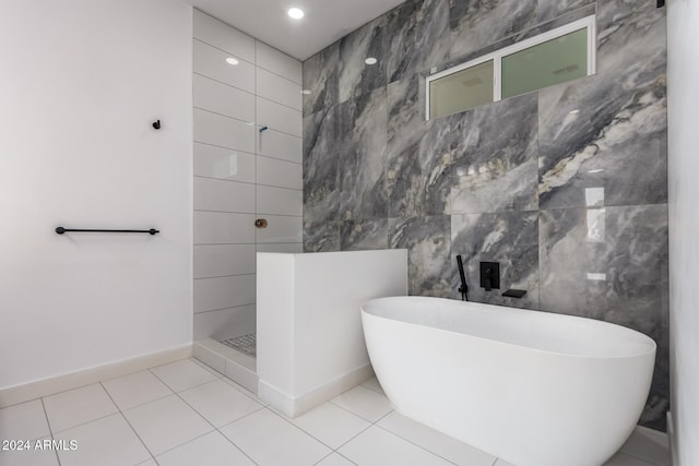 bathroom with plus walk in shower, tile patterned flooring, and tile walls