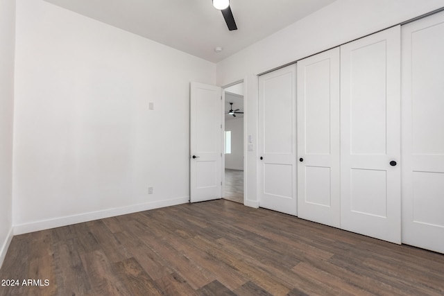 unfurnished bedroom with a closet, dark wood-type flooring, and ceiling fan