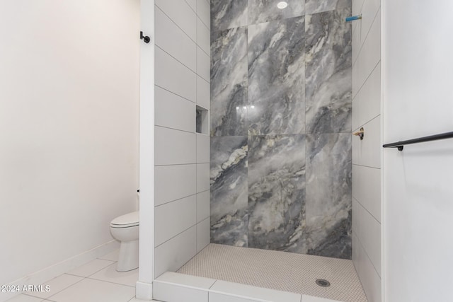 bathroom with a tile shower, tile patterned floors, and toilet