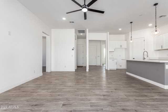 unfurnished living room featuring ceiling fan and light wood-type flooring