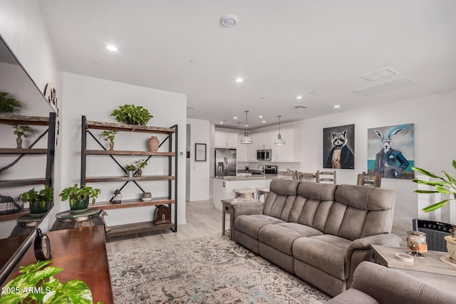 living room with sink and light wood-type flooring