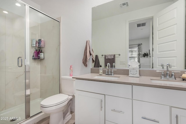 bathroom featuring vanity, toilet, and an enclosed shower