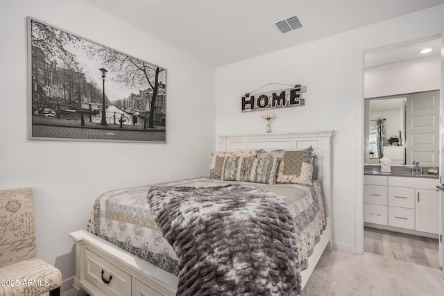 bedroom with light carpet and sink