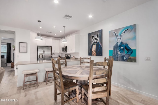 dining space with light hardwood / wood-style floors and sink