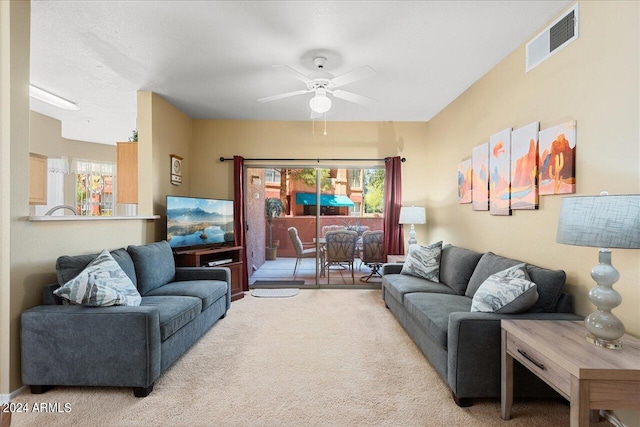 carpeted living room featuring ceiling fan