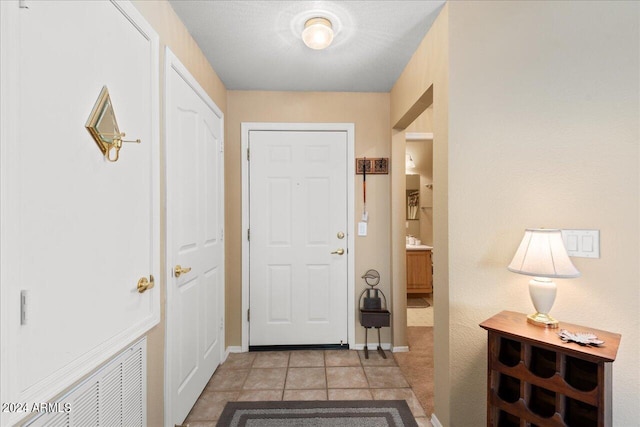 doorway with light tile patterned flooring