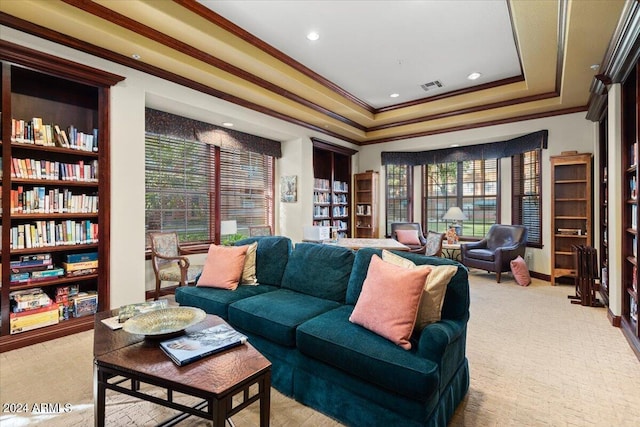 living room with light colored carpet, crown molding, and a tray ceiling