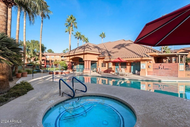 view of swimming pool featuring a community hot tub and a patio area