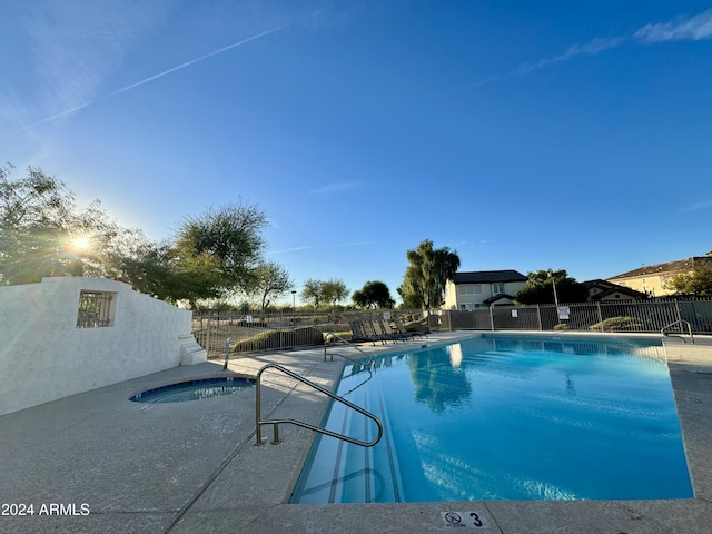 view of swimming pool with a hot tub