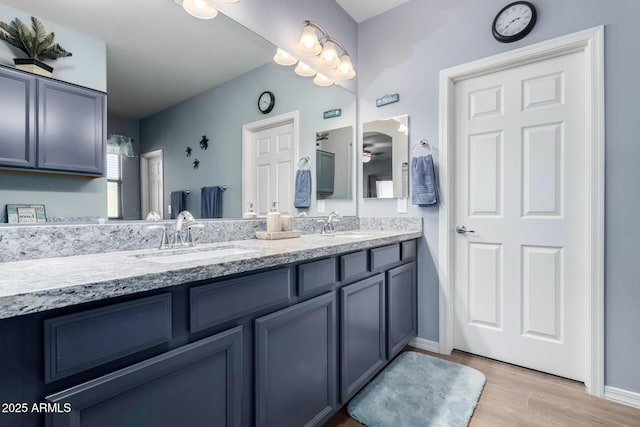 bathroom with hardwood / wood-style flooring, vanity, and ceiling fan